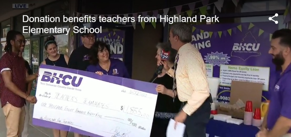 Teachers stand behind a giant check from BHCU.