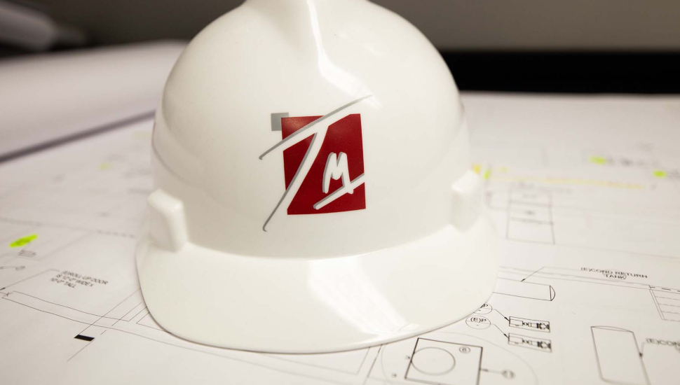 Hard hat construction hat resting on blueprints