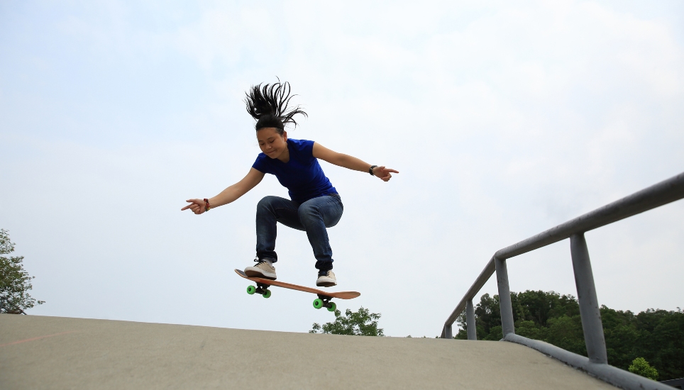 A woman skateboarding at a skatepark.