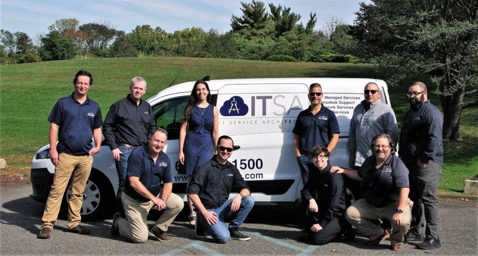 Employees of ITService ArchiTechs LLC standing outside their van. IT Service ArchiTechs is on the Soaring 76 list.