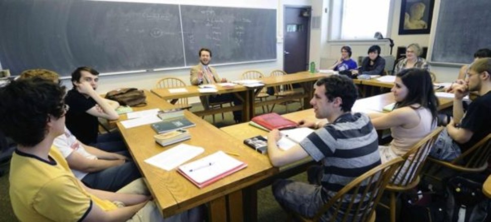 College students and faculty at a table in a discussion