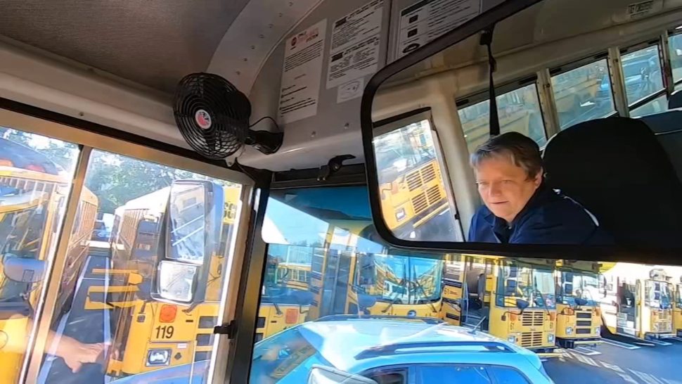 The reflection of an Upper Darby school bus driver in the bus mirror.