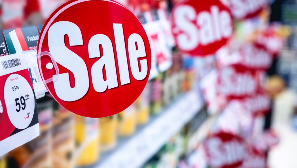 Store shelves with multiple red sale signs