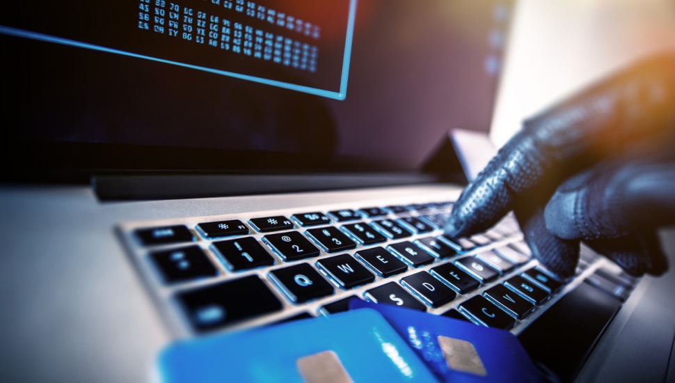 A hacker at a computer keyboard.