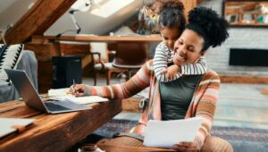 Black woman with her child as she works from home