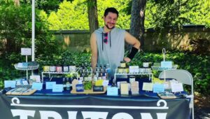 Jesse Brajuha at a table offering his Triton Soap & Skincare products