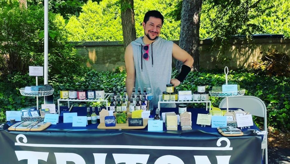 Jesse Brajuha at a table offering his Triton Soap & Skincare products