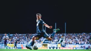 A Philadelphia Union soccer player running with the ball during a game at Subaru Park in Chester.