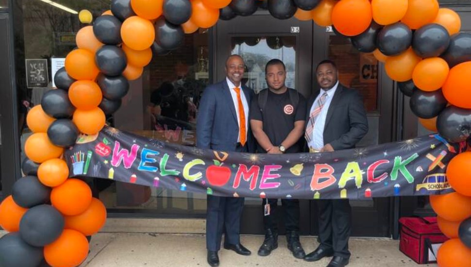 Chester Upland Superintendent Craig Parkinson (left) and Receiver Nafis Nichols welcome back students at an Aug. 29 bell-ringing ceremony.