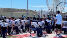 Villanova Wildcats have football practice while an Ocean City Ferris wheel looms in the background.