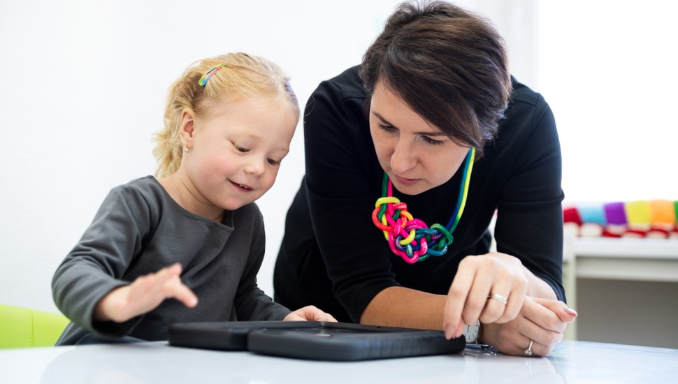 Qualified staff work with this girl toddler on a fun occupational therapy activity