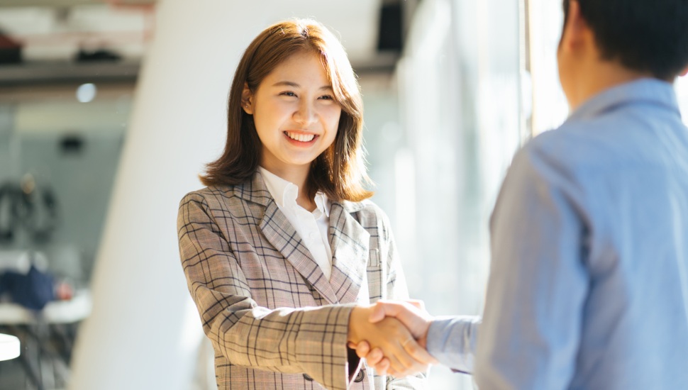 A businessman and woman shake hands