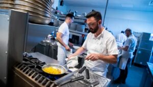 (left) Nicholas Elmi, chef/owner, and (center) Michael Millon, executive chef, work in the kitchen at Lark in Bala Cynwyd.
