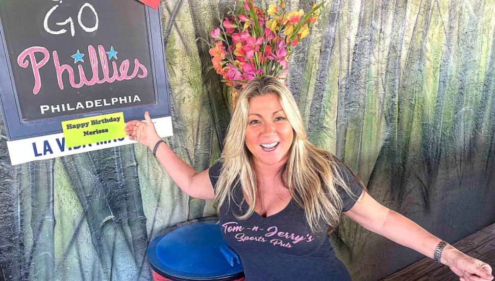 Yom and Jerry's co-owner Nerissa Burns next to a 'Go Phillies' sign