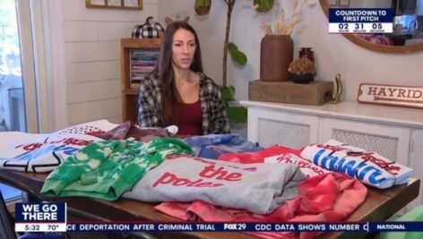 Ellen Paskill of Aston in her home shop with some of her Phillies shirts