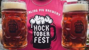 Two mugs of Hocktoberfest beer from Sterling Pig Brewery in Media is on display along with someone wearing a Hocktoberfest T-shirt