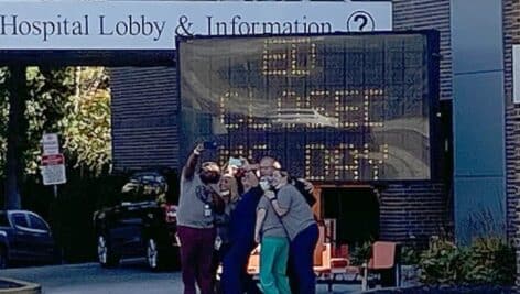 The emergency department staff at Delaware County Memorial Hospital takes a selfie in fron of the "ED closed" sign