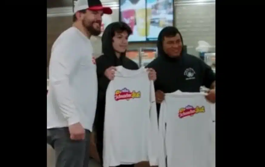 Kyle Schwarber poses with fans holding SchwarberFest T-shirts at a Wawa store.