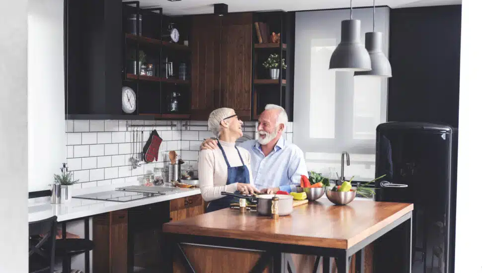 A senior couple cooking vegetables in a kitchen