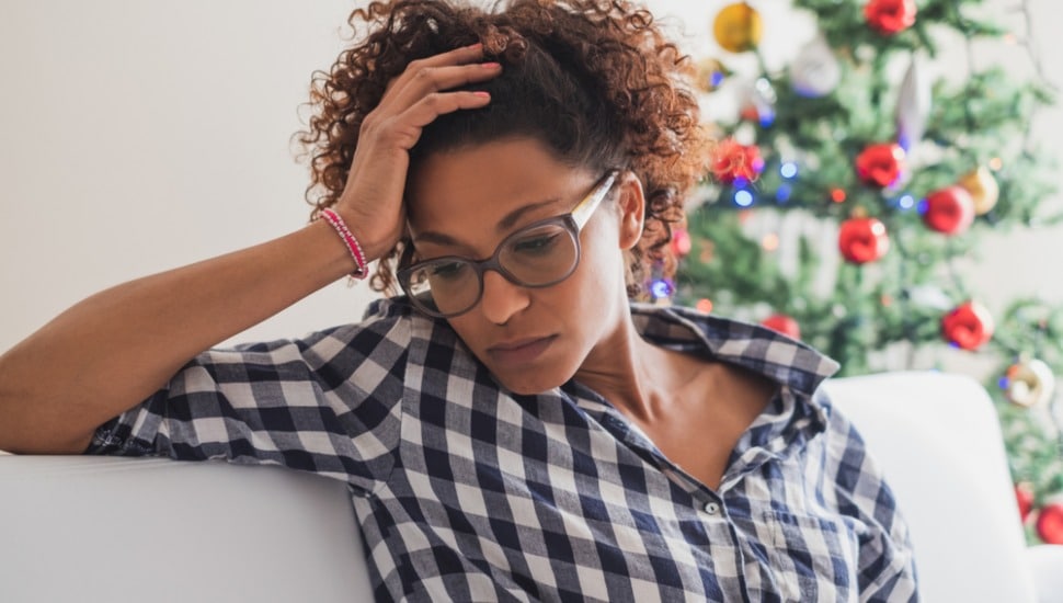 A woman is sitting looking anxious and worried