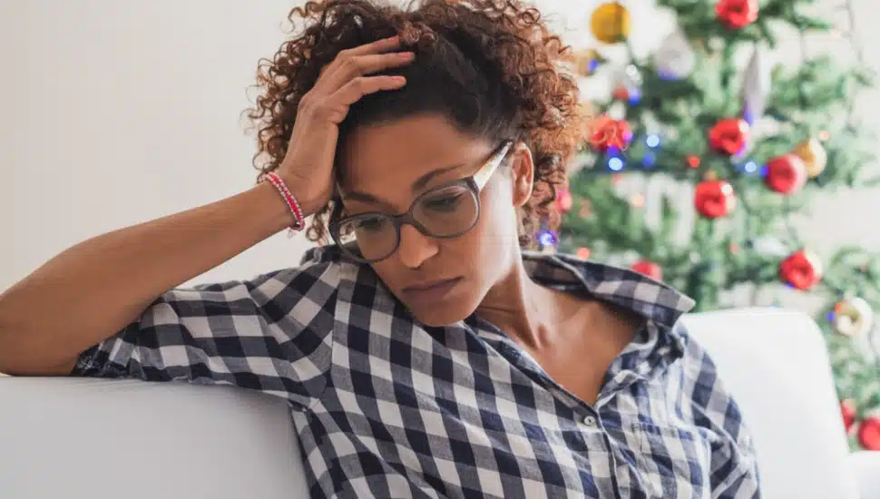 A woman is sitting looking anxious and worried