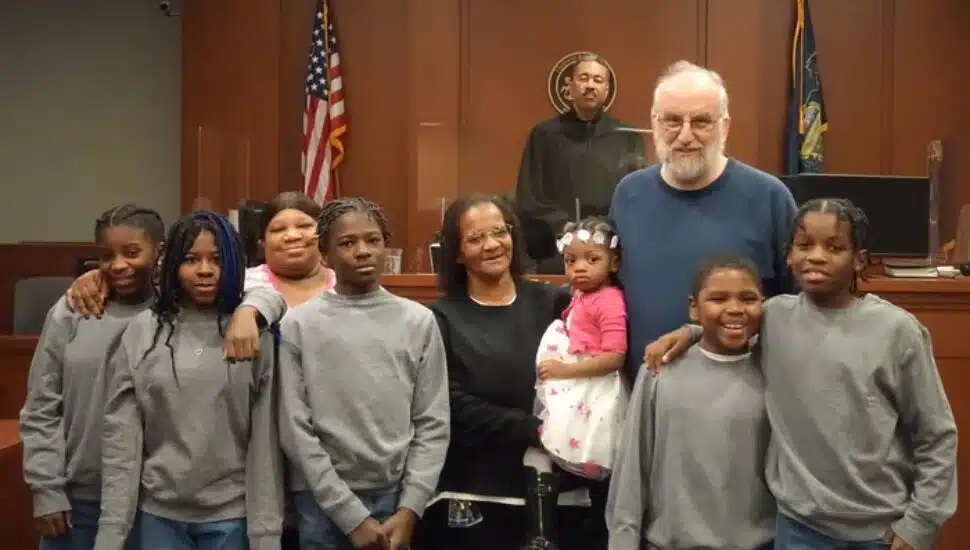 From left, Kash'ae, Kiaira, Flora (one of her biological children), Rah'mir, Flora (holding Amyah), Mark, Chase, and Zah'mir on the day Amyah was adopted.