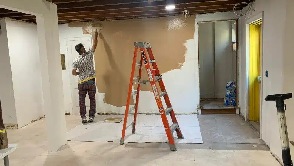 A man paints the walls of the Breaking Bread Community shelter in Upper Darby prior to its opening in December 2022