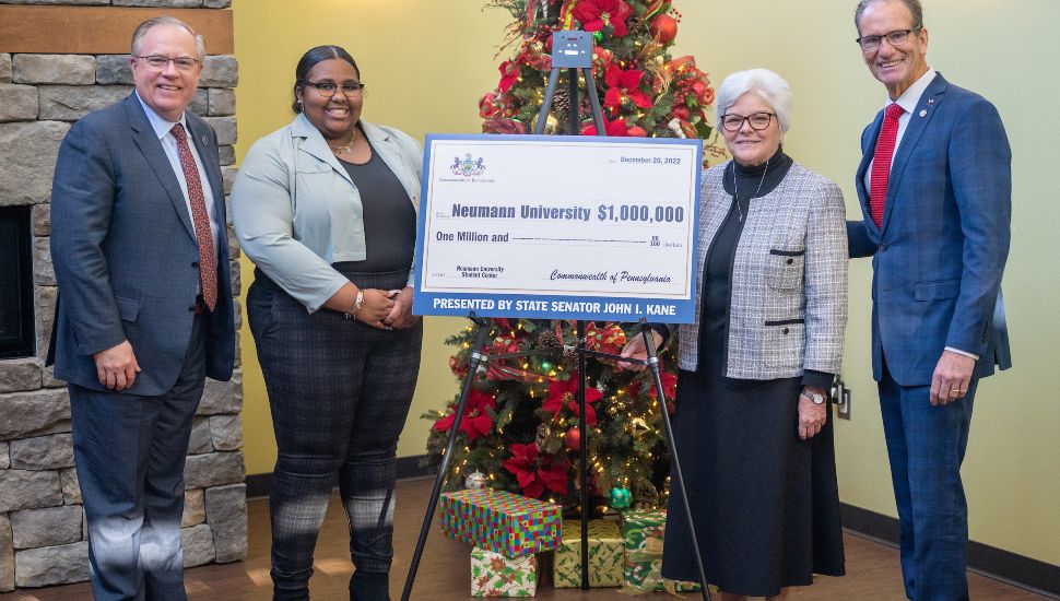 State Senator John Kane (right) presents a state grant for $1 million to Dr. Chris Domes, Student Government Association President JaNiece Davis, and Sr. Kathy Dougherty, university vice president.