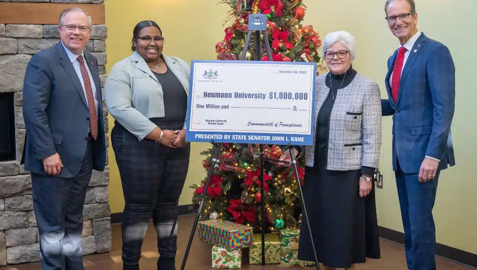 State Senator John Kane (right) presents a state grant for $1 million to Dr. Chris Domes, Student Government Association President JaNiece Davis, and Sr. Kathy Dougherty, university vice president.