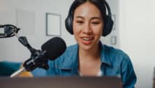 An Asian girl records a podcast on a laptop computer from a home studio, among a group these days of women storytellers