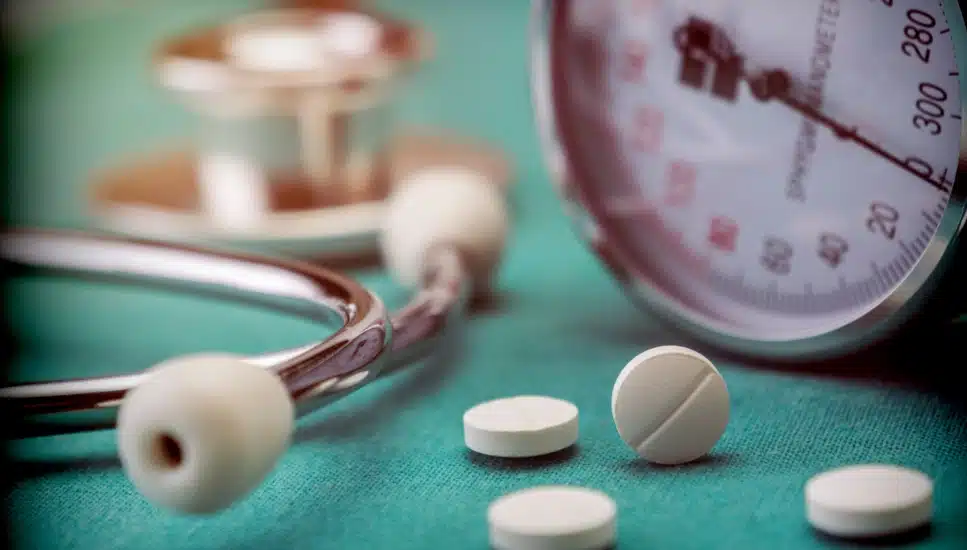 Blood pressure medicine next to a stethoscope and a blood pressure gauge