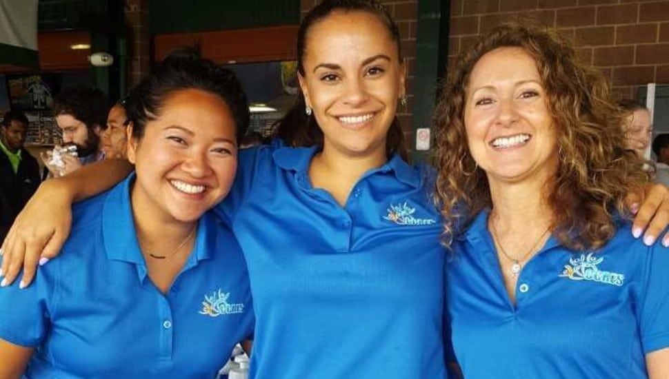 Three smiling women wearing CCRES shirts