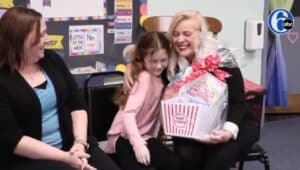 Peggy Jansen presents a gift basket to Andrea and Liz Dwyer