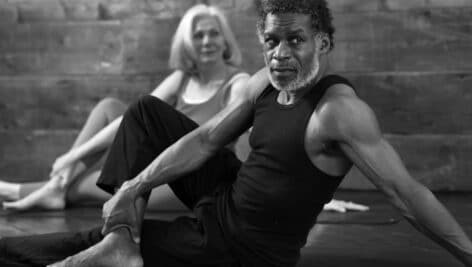 A man and a woman seated in a yoga position