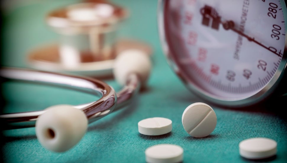 Blood pressure medicine next to a blood pressure gauge and a stethoscope