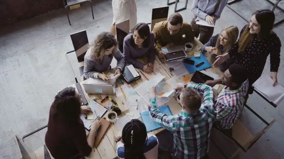 Young people gathered around a table talking and sharing time together