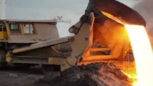 A slap-pot carrier spills molten slag onto a cooling area
