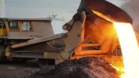 A slap-pot carrier spills molten slag onto a cooling area