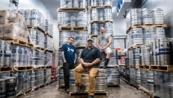 Surrounded by beer barrels are (from left) Joe Ruthig, Michael Stiglitz and Bob Barrar.