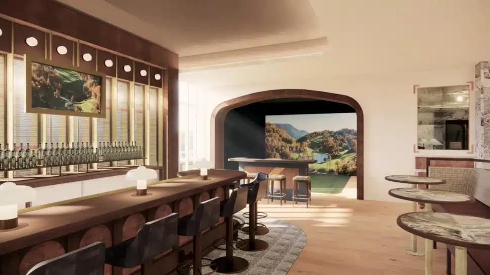 A look inside a room at an Intown Golf Club, with a bar, tables and a golf simulator on the far side of the room