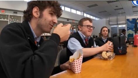 Michael Schuller (middle) having lunch with two peer mentoring students at Archbishop Carroll High School