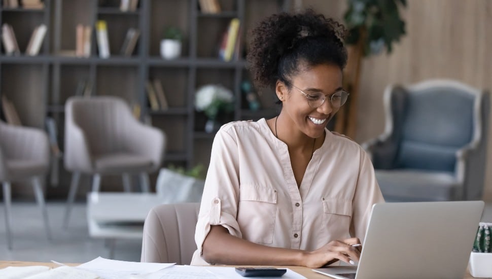 A woman laughing while at work in a job over 150000