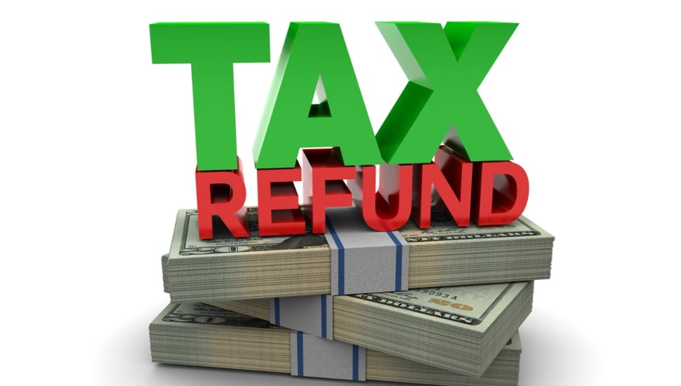 A pile of bound up cash with the words Tax Refund on top of the pile of cash