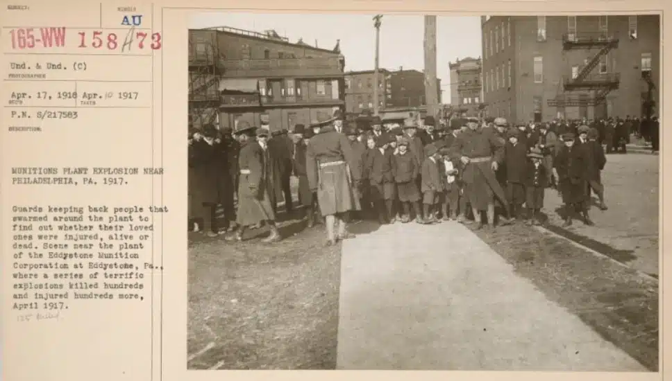 Crowds are held back by guards as they await news of the workers after an explosion at an Eddystone munitions factory in 1917