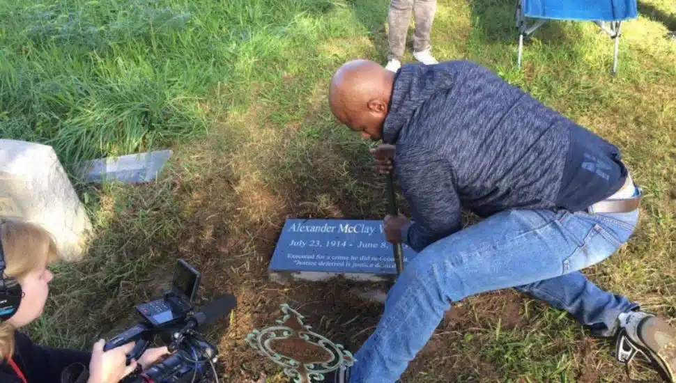 Family members place a marker on the grave of Alexander McClay Williams in Chester Township in October 2018.