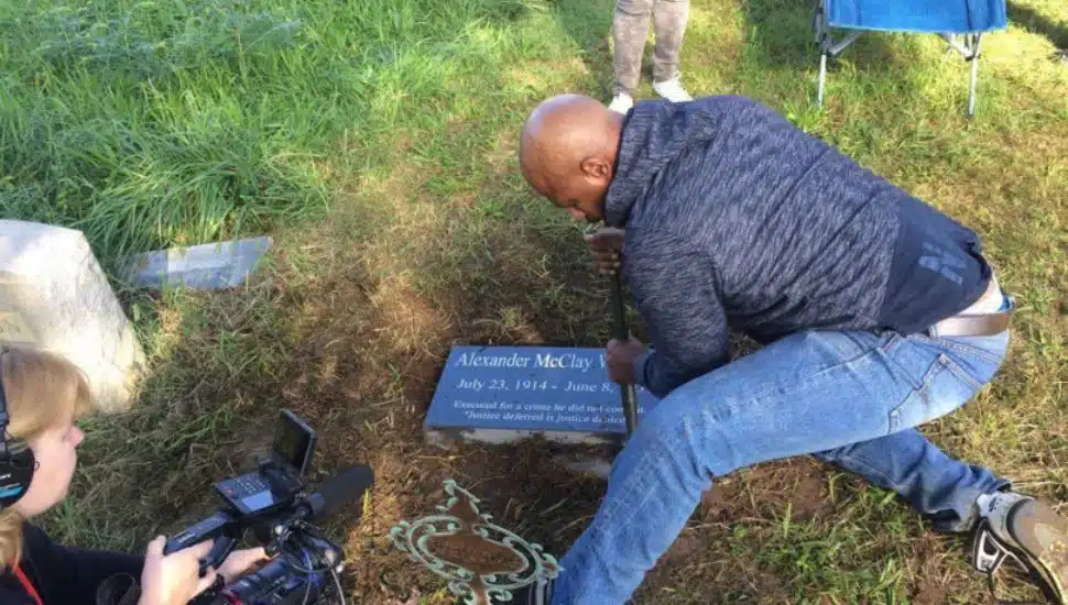 Family members place a marker on the grave of Alexander McClay Williams in Chester Township in October 2018.