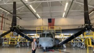 Boeing plant executive Shane Openshaw with a V-22 Osprey in 2022.