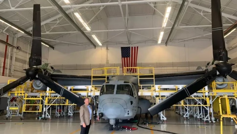 Boeing plant executive Shane Openshaw with a V-22 Osprey in 2022.