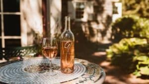 A bottle and glass of the Grace Winery rose' wine on a table
