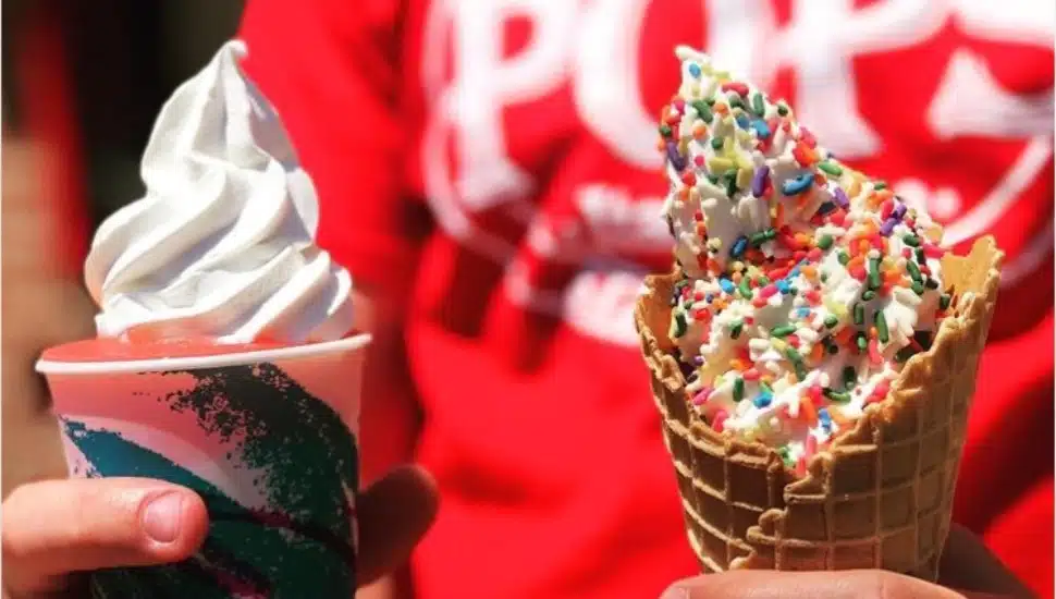 Someone wearing a Pop's Water Ice T-shirt holding two decorated ice cream cones